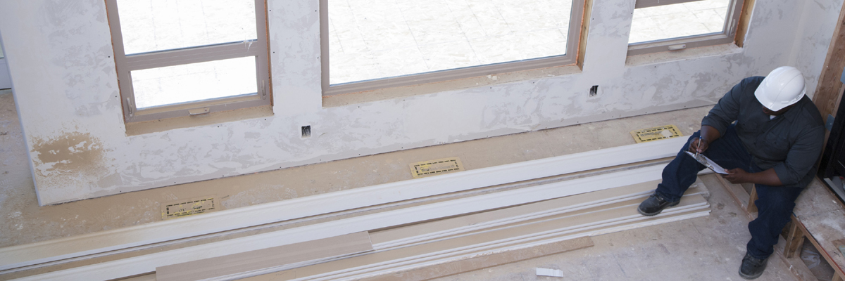 contractor sitting in unfinished room reviewing his notes