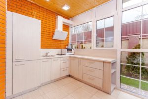 remodelled kitchen with with cabinets and outer wall and orange brick walls